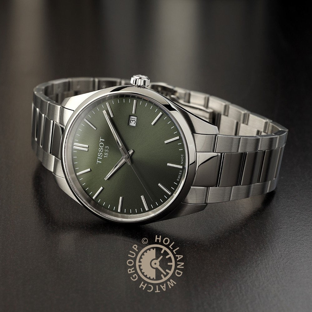 Een roestvrijstalen Tissot PR 100 herenhorloge met groene wijzerplaat, datumaanduiding op 3 uur en metalen schakelarmband rust op een donker oppervlak met het logo van Holland Watch Group.
