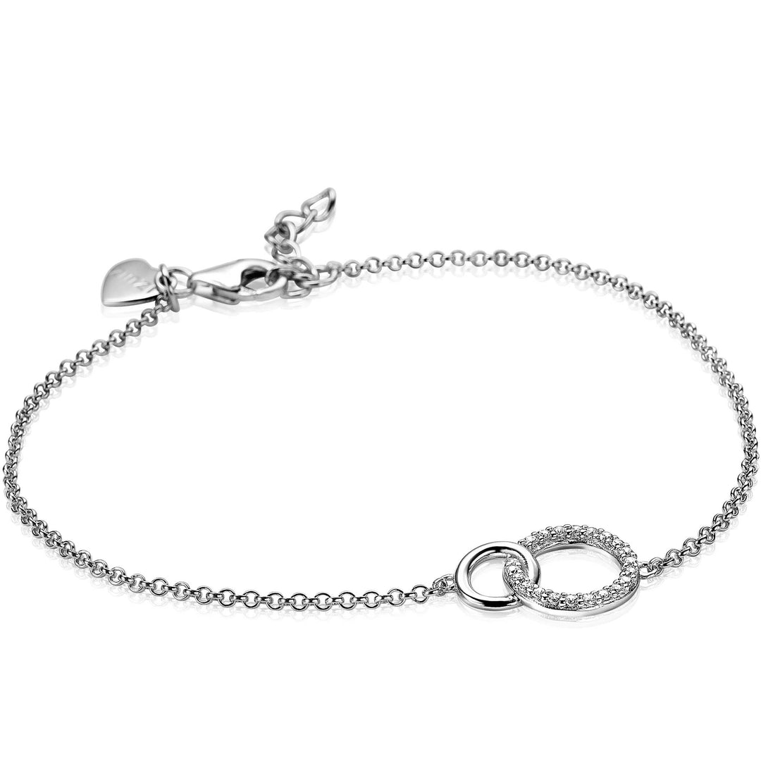 De Zinzi Armband Zilver Zia1782 benadrukt een delicate ketting met twee in elkaar grijpende cirkels - een gladde, de andere versierd met kleine edelstenen. Deze elegante armband bevat een karabijnsluiting en een klein hartje bij de sluiting.