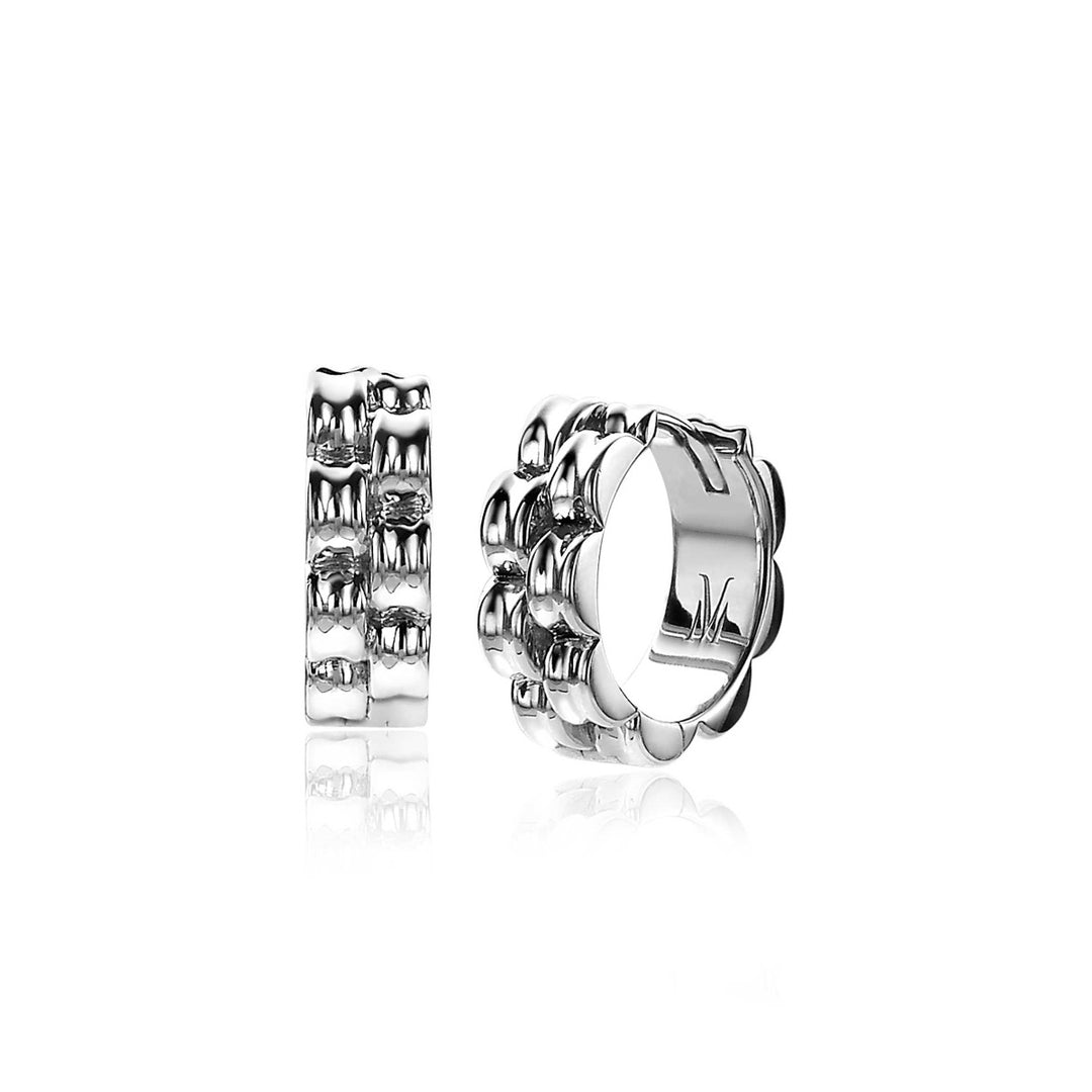 De Zinzi Oorbellen Zilver Mvo23 zijn voorzien van dikke zilveren creolen met een geschulpt patroon en gepolijste afwerking. Hun luxe scharniersluiting zorgt voor een veilige pasvorm, prachtig naast elkaar tentoongesteld - de ene toont de voorkant, de andere benadrukt elegant het zijaanzicht.